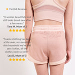 Girl wearing a pink plastic free sports shorts and pink sports crop top with text on verified reviews. 