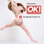 Dancer in pink polyester free sports shorts and pink organic cotton crop t-shirt with OK! Independent logo on a white background.  