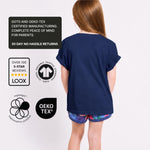 Girl wearing a Svante navy blue regenerative cotton t-shirt with certification logos on a white background. 