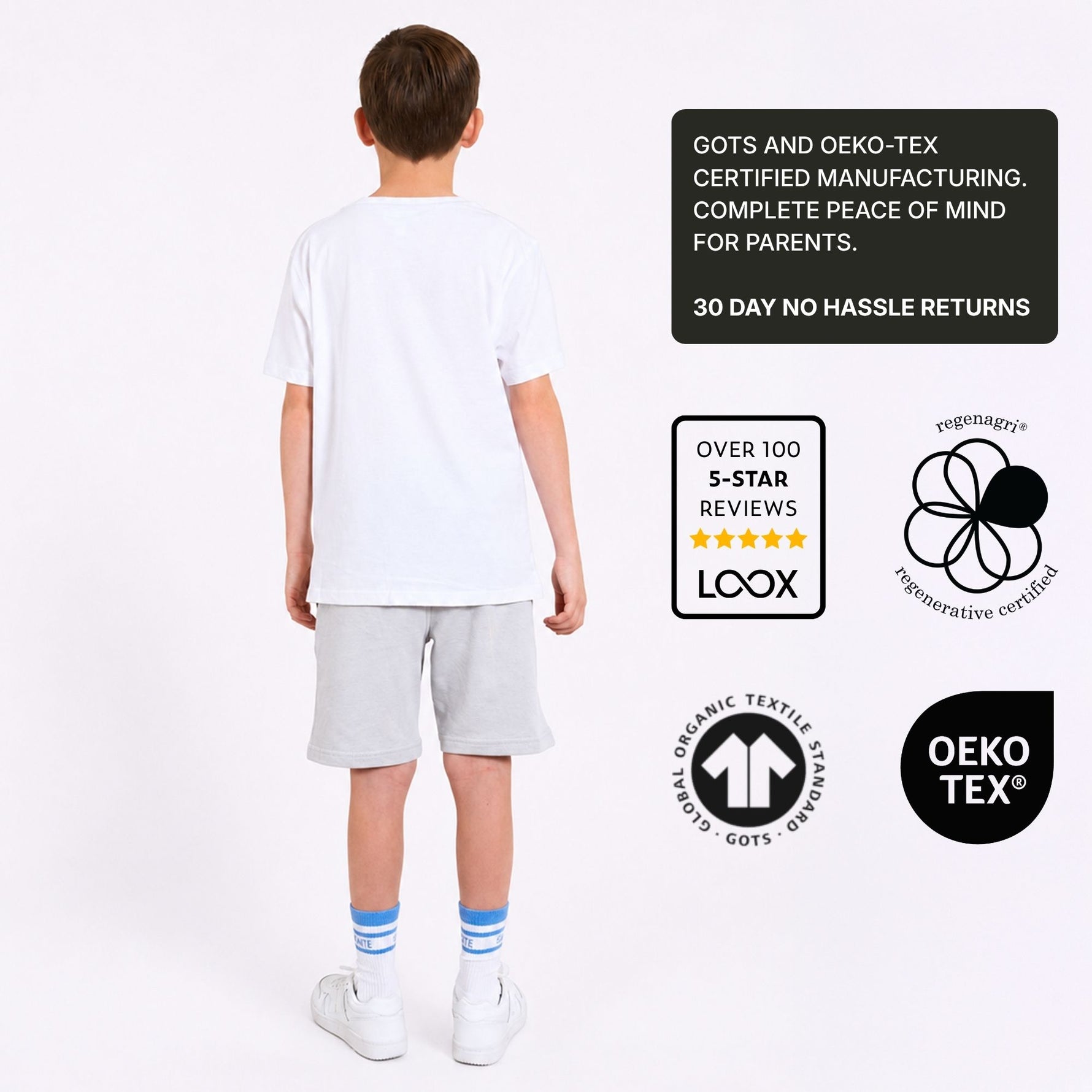 Boy wearing a white organic cotton t-shirt and grey organic cotton jersey shorts with certification logos on a white background. 
