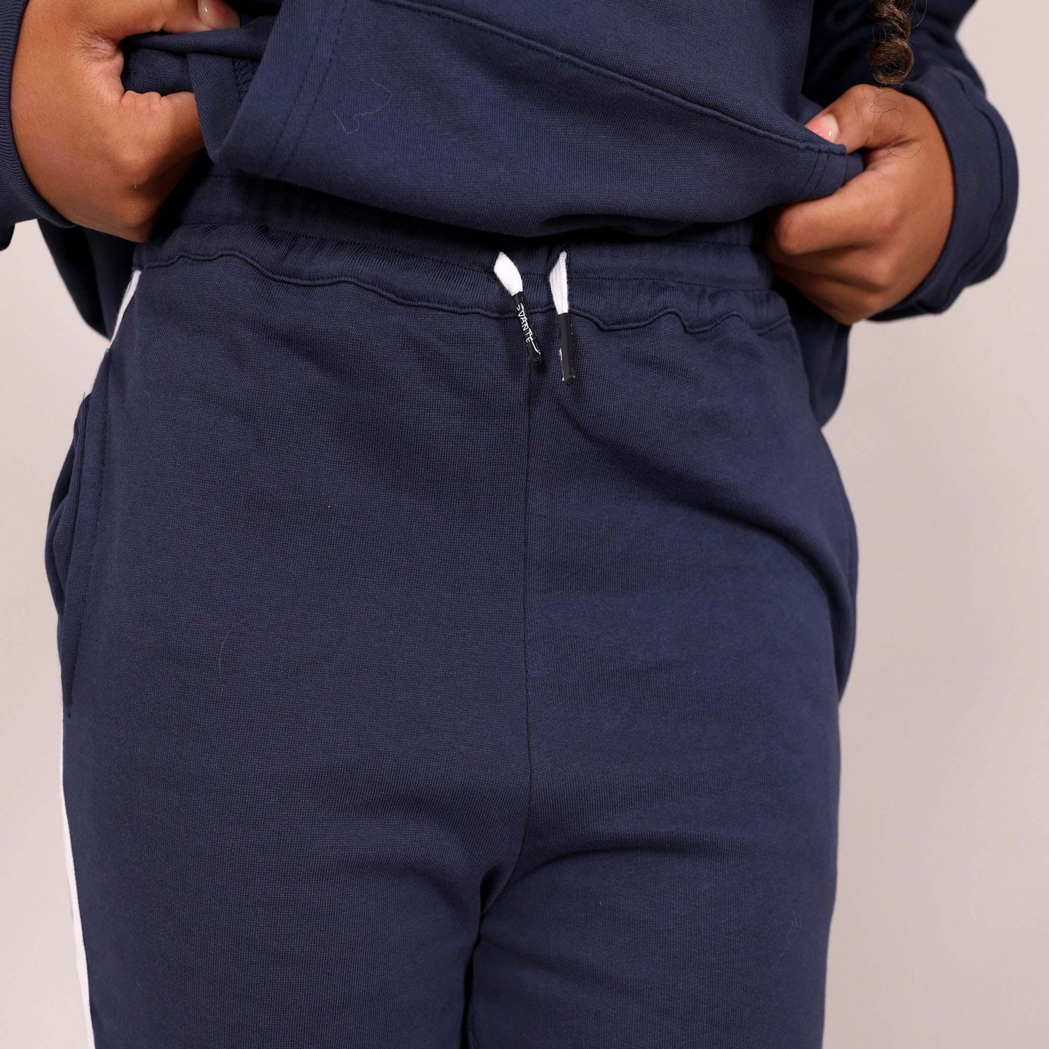 Close up of organic cotton navy blue joggers waist band and 'Svante' branded organic cotton draw strings with a plain background. 