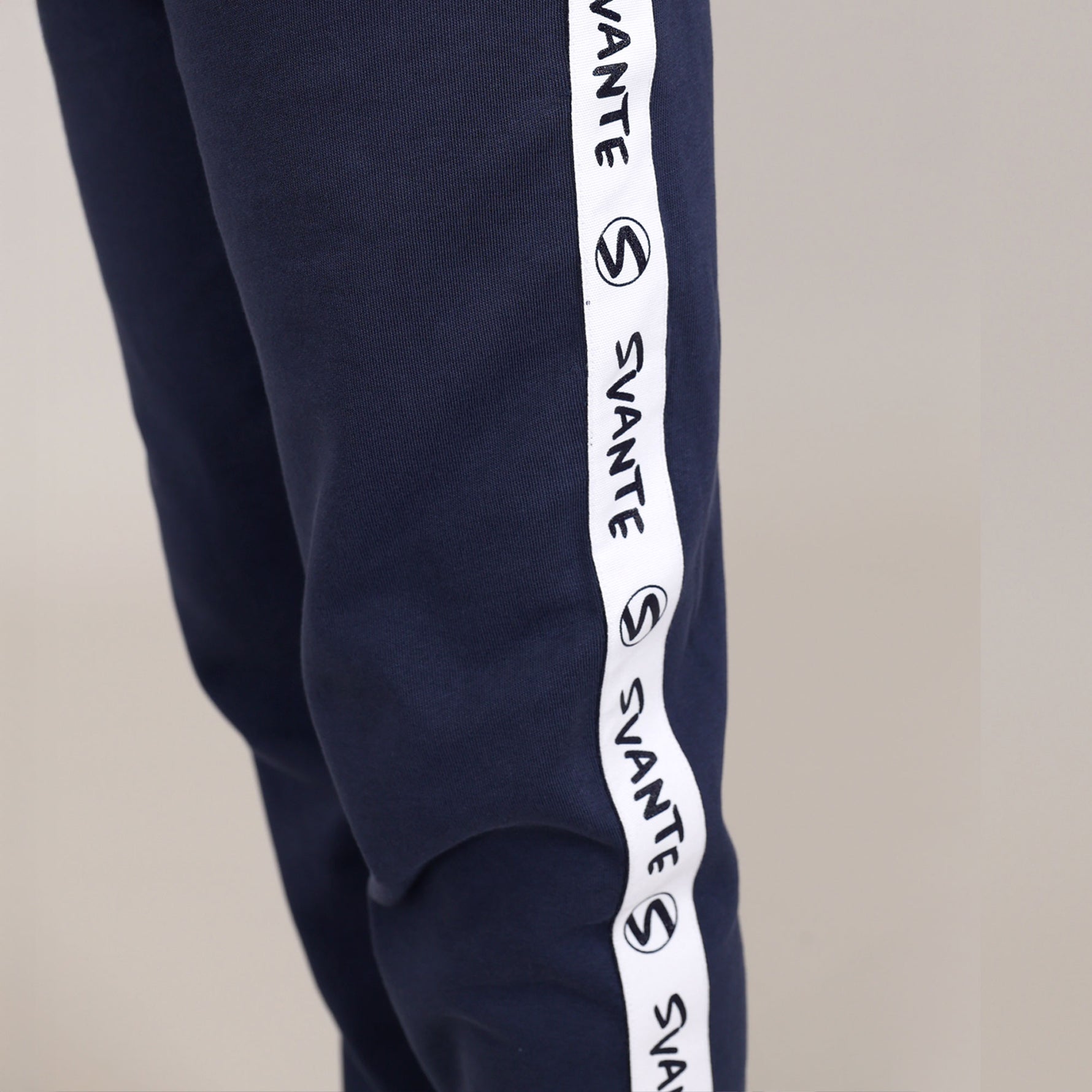 close up of side leg of organic cotton navy blue regenerative cotton joggers with 'Svante' logo running down the side. 