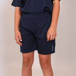 Front close up image of boy wearing navy blue sports shorts with 'Svante' brand logo on the leg on a plain background